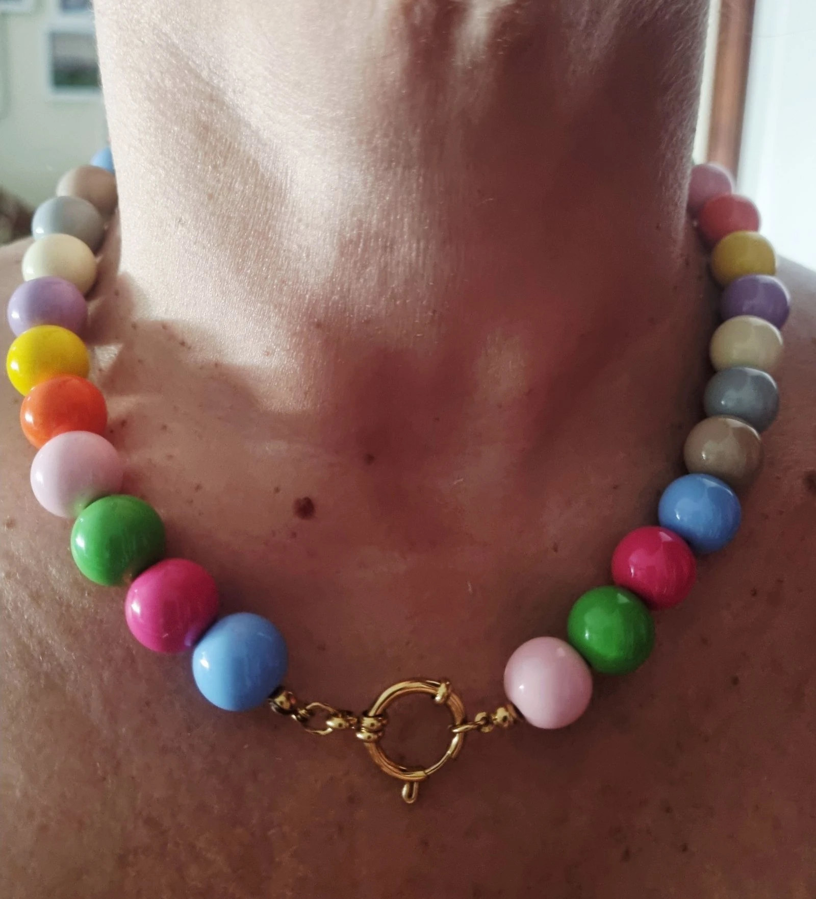 Colar dourado, em aço, com bolinhas coloridas em acrílico. Fecho bóia.
